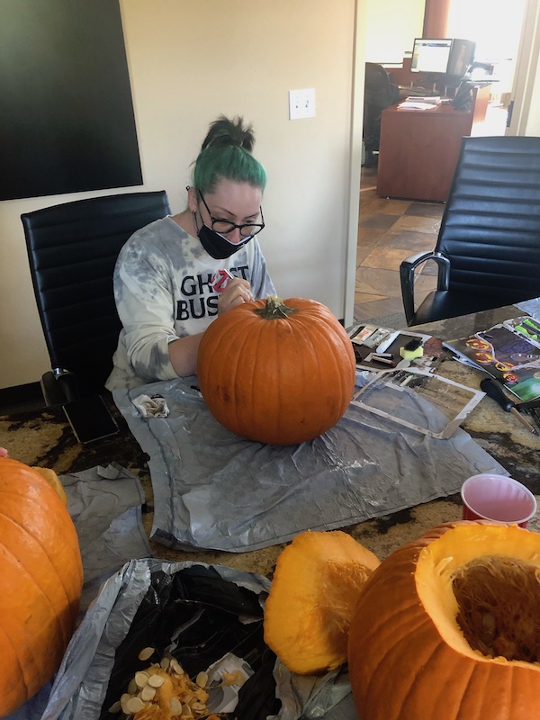 Caiti carves a pumpkin.